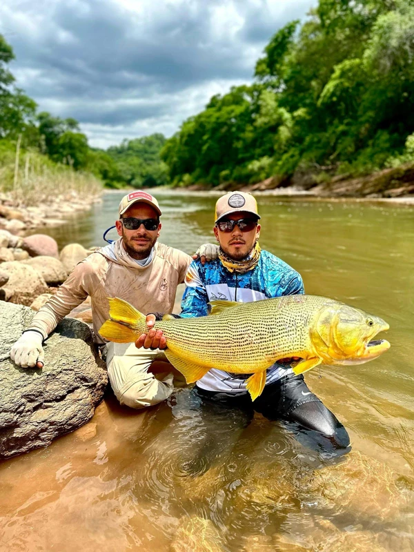 Sharing a catch beside the river.