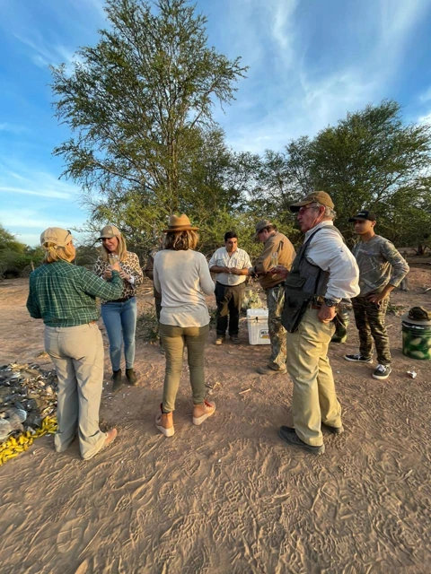 The group shares a moment beside the trees.